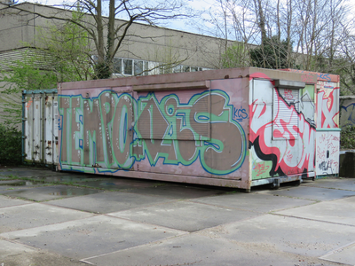 829805 Afbeelding van graffiti op een oude bouwkeet en containers, op het terrein van de voormalige werkplaatsen van de ...